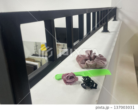 Hair accessories on a railing in a modern space during daylight hours Hair accessories on a railing in a modern space during daylight hours 137003031