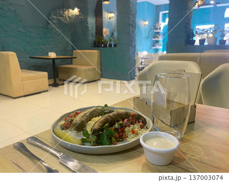 a plate of rice and sausages on a wooden table 137003074