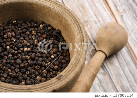 Black pepper corn into mortar and pestle 137005114