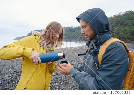 Couple drinks tea by winter sea shore 137005322