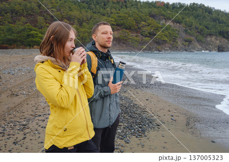 Couple drinks tea by winter sea shore 137005323