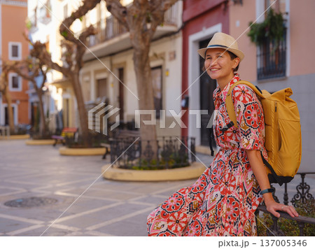 Woman strolls through colorful streets of Spanish coastal town Woman strolls through colorful streets of Spanish coastal town 137005346