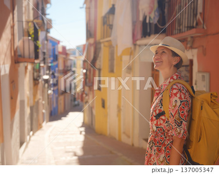 Woman strolls through colorful streets of Spanish coastal town Woman strolls through colorful streets of Spanish coastal town 137005347