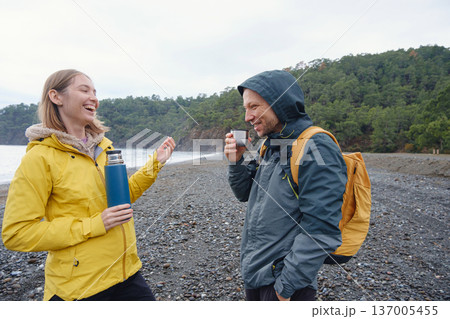 Couple drinks tea by winter sea shore 137005455