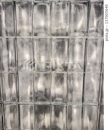 Textured glass block wall. Abstract architectural background with light reflections and distortion. Textured glass block wall. Abstract architectural background with light reflections and distortion. 137005640