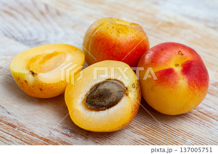 Image of ripe juicy apricots on wooden table in kitchen Image of ripe juicy apricots on wooden table in kitchen 137005751
