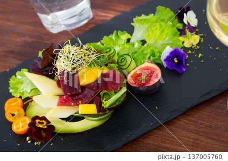Close up of tasty salad of raw tuna, avocado, mango and greens Close up of tasty salad of raw tuna, avocado, mango and greens 137005760