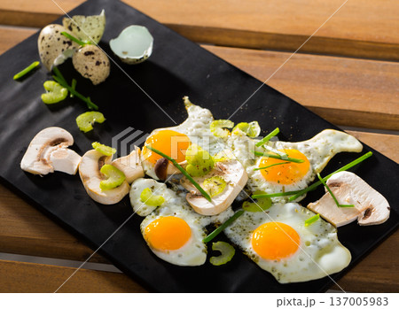 Fried quail eggs with champignons 137005983
