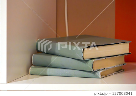 Hard cover books on shelf 137008041