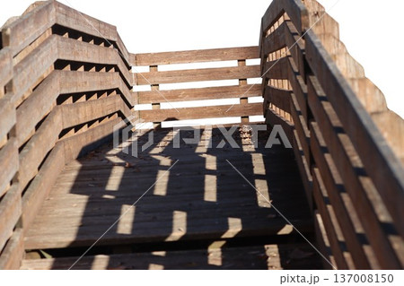 Wooden walkway structure with railing shadows creating patterns Wooden walkway structure with railing shadows creating patterns 137008150
