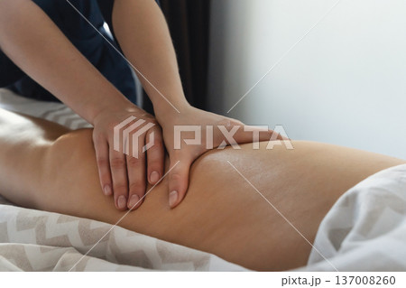 Professional hands performing therapeutic massage on person's leg. Therapist massaging client's leg for rehabilitation relaxation Professional hands performing therapeutic massage on person's leg. Therapist massaging client's leg for rehabilitation relaxation 137008260