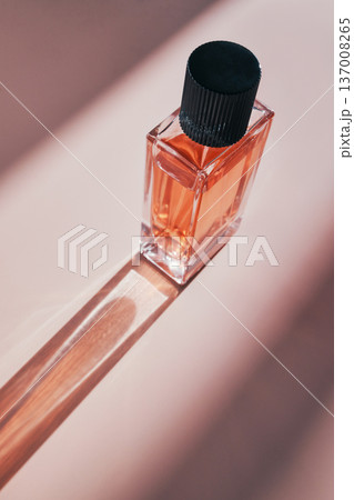 Luxury fragrance bottle with black cap creating contrasting shadow on soft surface Luxury fragrance bottle with black cap creating contrasting shadow on soft surface 137008265