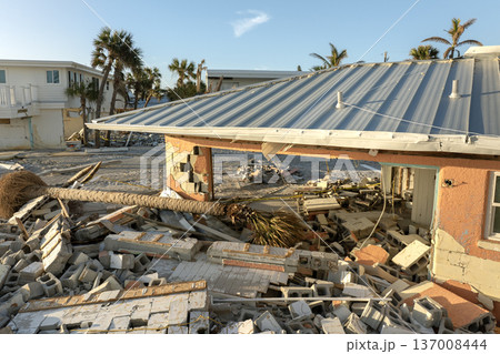 Ruined buildings in need of demolition or repair. Storm surge water and wind damaged houses roof and collapsed walls after hurricane in Florida 137008444