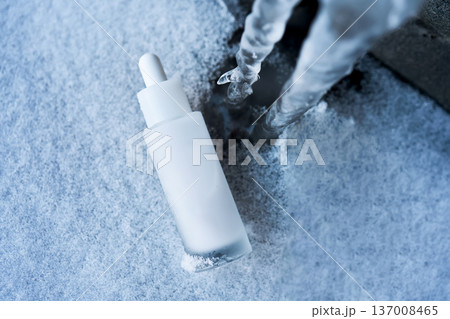 Skincare serum bottle on snow covered ice 137008465
