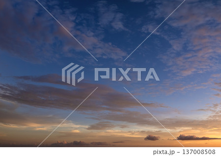 Bright sunset with setting sun behind vivid orange and yellow clouds 137008508