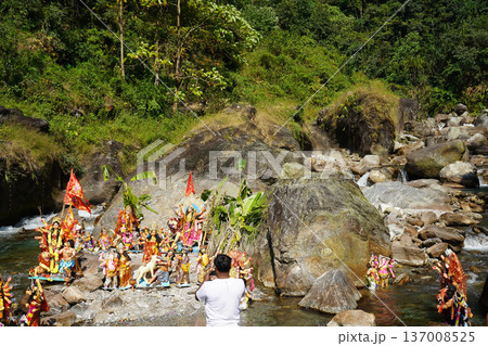 Immersion of Hindu goddess Durga idols in a mountain river during a religious festival 137008525