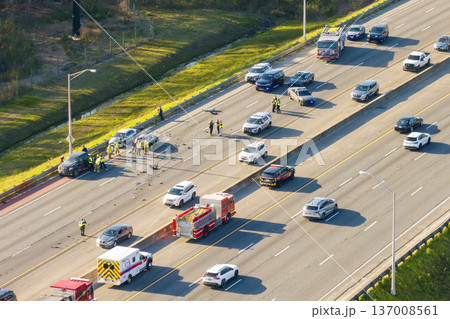 First responders at car accident site in Florida. Emergency services personnel helping victims of car crash on freeway in USA. 137008561
