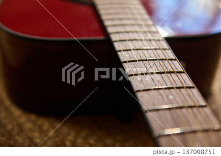 Close-Up Acoustic Guitar Fretboard and Strings on Red Body With Shallow Depth of Field 137008751