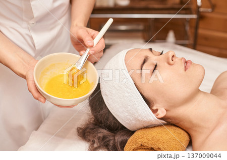 Female Caucasian Young Adult Receiving Relaxing Facial Treatment With Natural Mask In Spa For Skin Female Caucasian Young Adult Receiving Relaxing Facial Treatment With Natural Mask In Spa For Skin 137009044