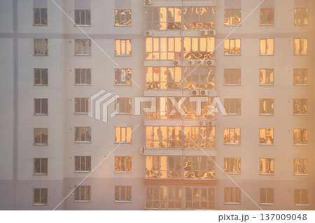 Urban Apartment Building With Reflective Windows At Sunset Creating Warm Golden Glow 137009048