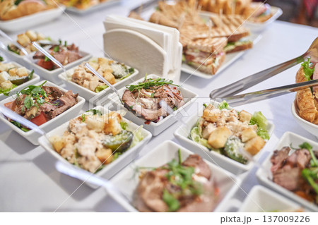 Assorted appetizers and sandwiches on elegant buffet table with fresh garnishes 137009226