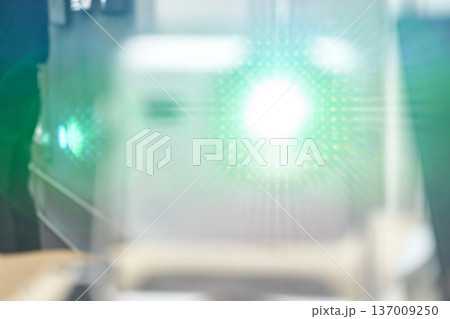 Blurred abstract green light beam with lens flare in a modern setting Blurred abstract green light beam with lens flare in a modern setting 137009250