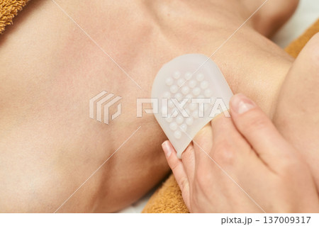 Woman Receiving Exfoliation Treatment With A Silicone Brush Pad On Her Neck Woman Receiving Exfoliation Treatment With A Silicone Brush Pad On Her Neck 137009317