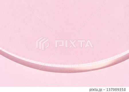 Minimalist abstract curved line on pastel pink background with soft shadows and subtle texture 137009358