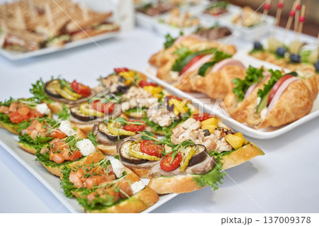 Elegant platters of mixed canapes and croissants with fresh vegetables and meats at a buffet Elegant platters of mixed canapes and croissants with fresh vegetables and meats at a buffet 137009378