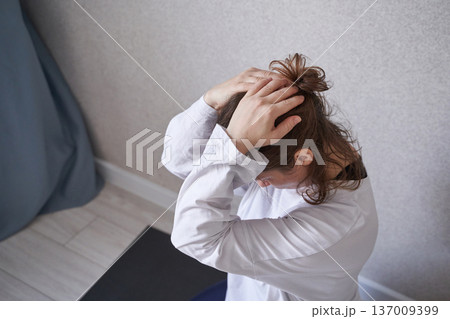 Young caucasian female in yoga retreat posing indoors with calm focus and relaxed expression Young caucasian female in yoga retreat posing indoors with calm focus and relaxed expression 137009399
