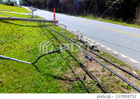 Power lines are seen downed next to road in rural area, causing a disruption to local utilities during tornado storm Power lines are seen downed next to road in rural area, causing a disruption to local utilities during tornado storm 137009732