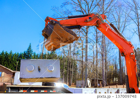 Construction equipment is lifting large concrete blocks uses excavator 137009748