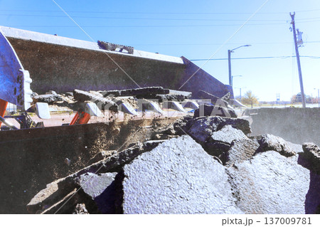 Tractor machine is breaking asphalt on road during road works Tractor machine is breaking asphalt on road during road works 137009781