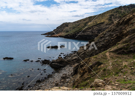 Coastal landscape of Menorca with cliffs meeting the sea under a cloudy sky. Coastal landscape of Menorca with cliffs meeting the sea under a cloudy sky. 137009912