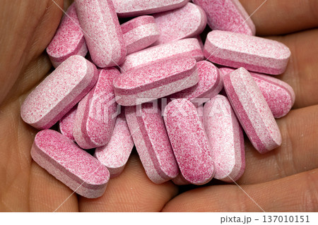Holding pink pills in hand 137010151
