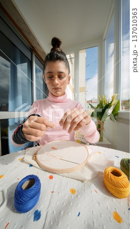 Creatively assembling decorative macrame pieces at her workspace Creatively assembling decorative macrame pieces at her workspace 137010363