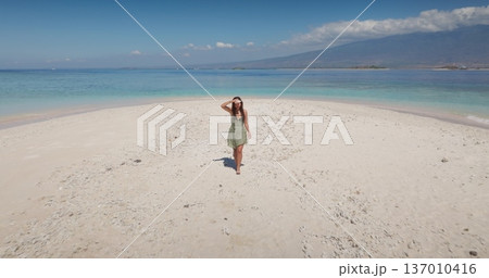 Beautiful woman relax on pristine white sandbar, turquoise water on tranquil Gili Islands sand beach, soaking up sunshine and a peaceful tropical escape. Summer vacation on Lombok. Aerial view 137010416