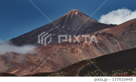 Tenerife, Canary Islands: Aerial view majestic Mount Teide, Spain's highest peak, rising above clouds in Tenerife's stunning landscape. Travel destination, nature background. Drone panorama 137010449