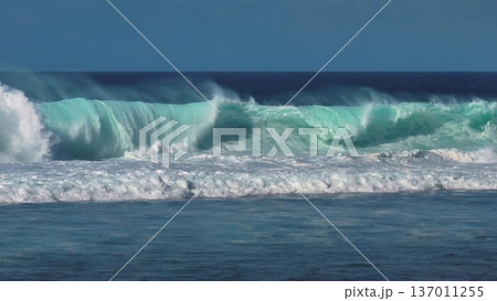 Powerful turquoise ocean wave cresting and breaking off Bali coast, white foam and spray capturing raw motion and energy of surf and tropical seascape on a clear day. Natural background, slow motion Powerful turquoise ocean wave cresting and breaking off Bali coast, white foam and spray capturing raw motion and energy of surf and tropical seascape on a clear day. Natural background, slow motion 137011255