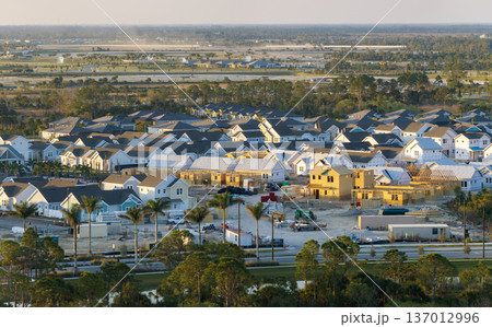 Aerial view of unfinished wooden frames of affordable houses under construction. Development of residential housing in American suburbs. Real estate market in the USA Aerial view of unfinished wooden frames of affordable houses under construction. Development of residential housing in American suburbs. Real estate market in the USA 137012996