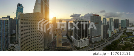 Aerial view of downtown district of of Miami Brickell in Florida, USA at sunset. High skyscraper buildings and street with cars and Metrorail traffic in modern american midtown 137013151