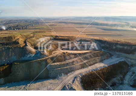 Aerial view of open pit mine of sandstone materials for construction industry with excavators and dump trucks. Heavy equipment in mining and production of useful minerals concept Aerial view of open pit mine of sandstone materials for construction industry with excavators and dump trucks. Heavy equipment in mining and production of useful minerals concept 137013160