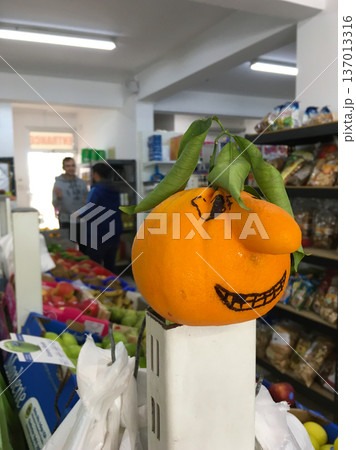 Orange with drawn funny face in grocery store. Playfulness, creativity and everyday humor in retail concept Orange with drawn funny face in grocery store. Playfulness, creativity and everyday humor in retail concept 137013316