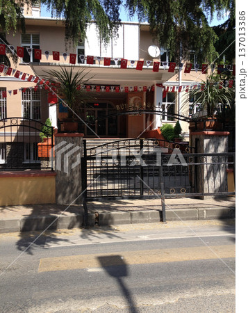 Entrance of institutional building decorated with national flags Turkey. Identity, patriotism, community celebration and public space Entrance of institutional building decorated with national flags Turkey. Identity, patriotism, community celebration and public space 137013386