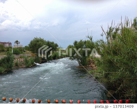 Mountain river flowing through green landscape in Antalya Turkey. Nature environment water ecology vegetation weather transition and seasonal atmosphere in coastal region. 137013409