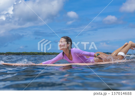 Relaxed Young Lady Enjoying Peaceful Surf Session Under Cloudy Sky Relaxed Young Lady Enjoying Peaceful Surf Session Under Cloudy Sky 137014688