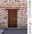 Rustic wooden door in a traditional stone and plaster wall with exposed rocks 137015096