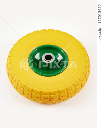 Wheel is pneumatic on a white background. Yellow rubber, green disc. 137015420