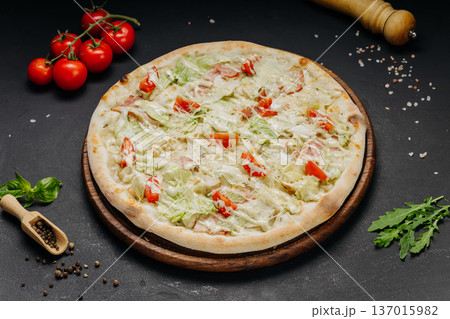 White pizza with chicken cheese lettuce and tomato on rustic dark background White pizza with chicken cheese lettuce and tomato on rustic dark background 137015982
