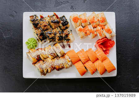 Assorted sushi rolls with salmon eel and tobiko served on white plate top view 137015989